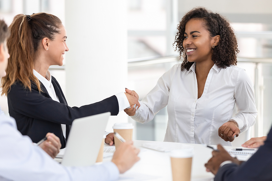 Woman shakes hand after being hired for new job