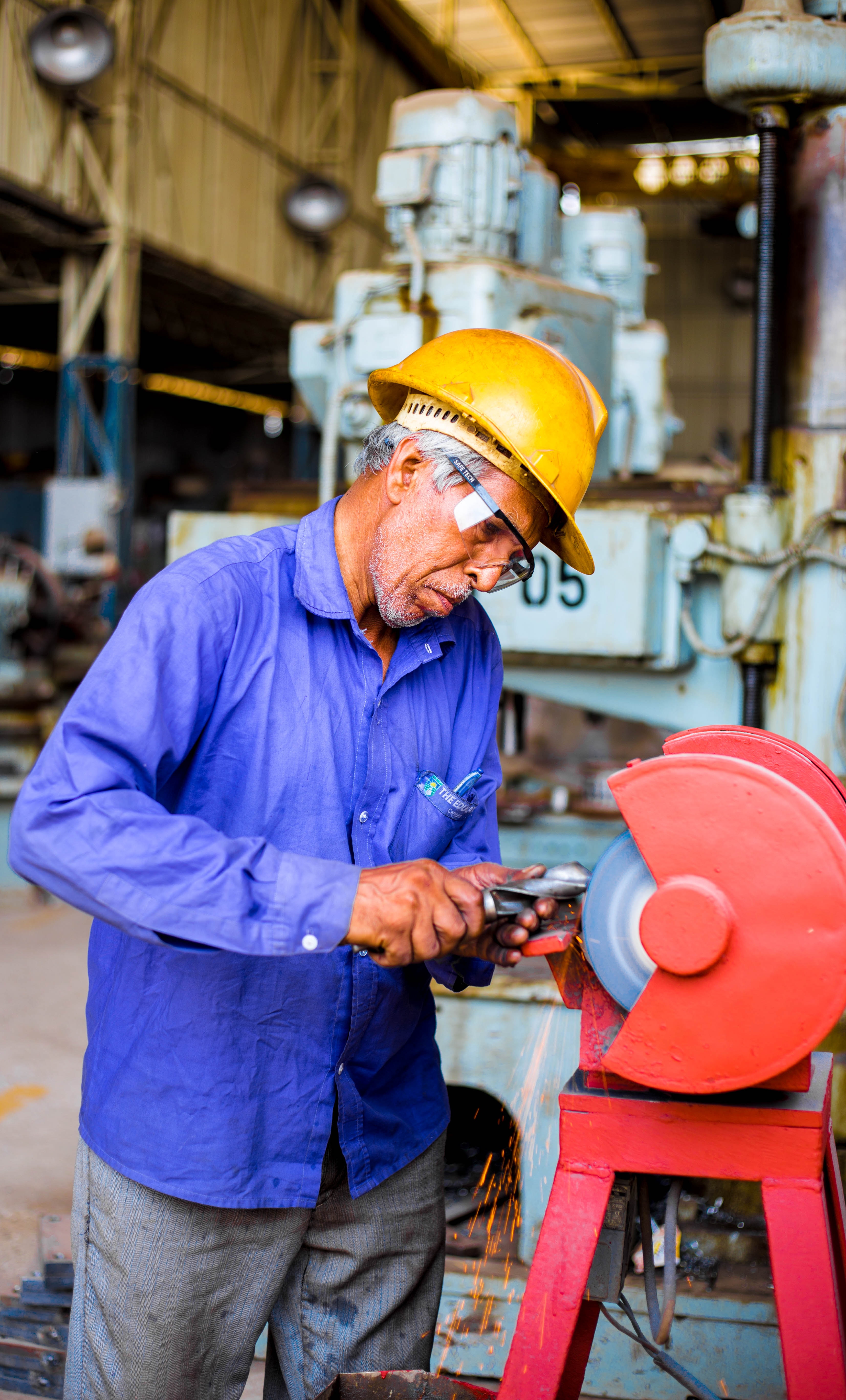 Worker grinds a drill bit