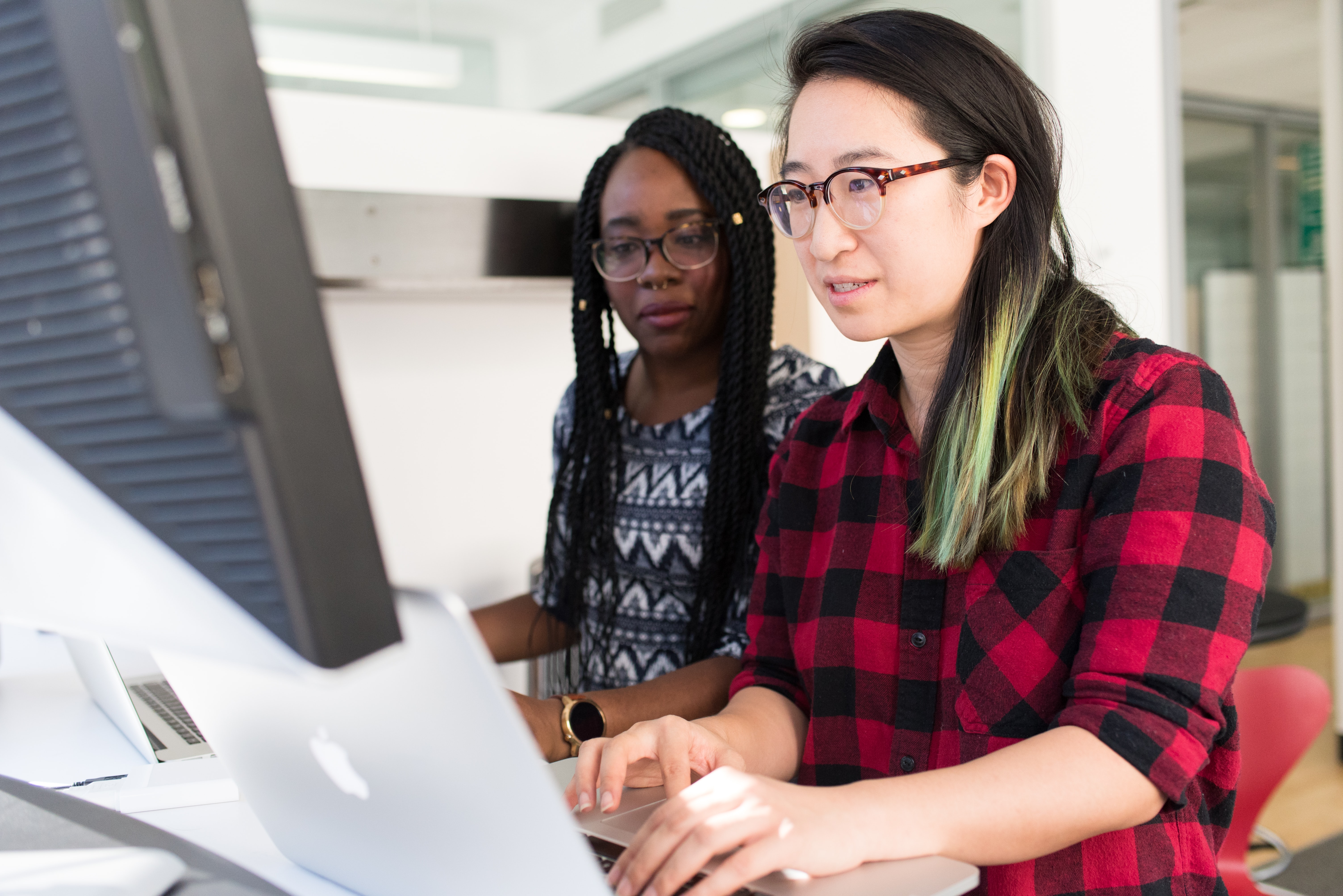 Women in tech work at monitors