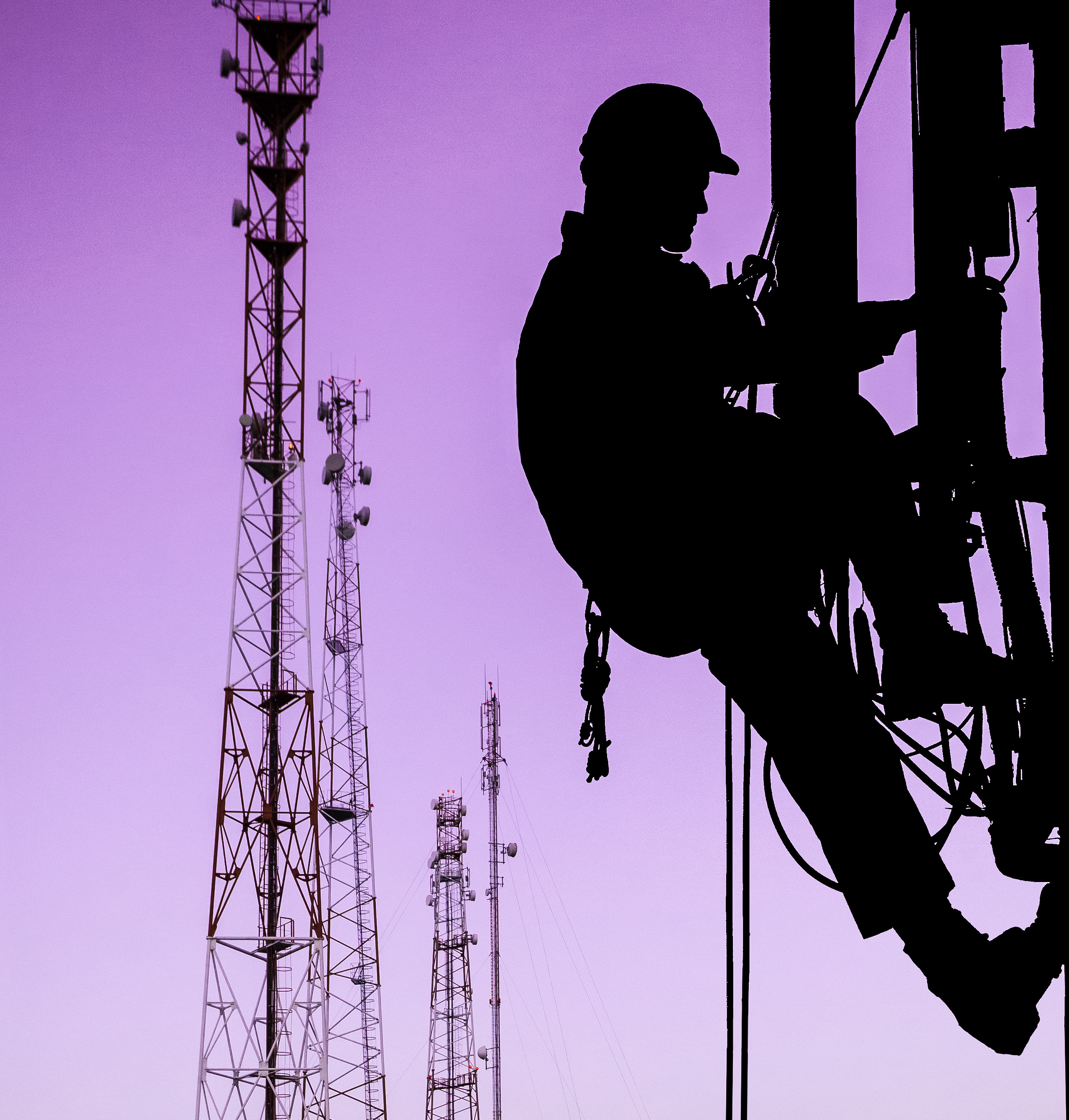 Electrical worker in silhouette climbing tower