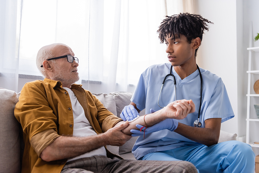 Home health care nurse assists patient