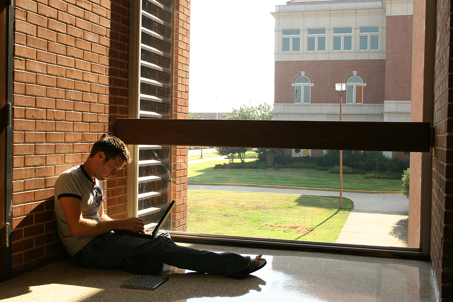 Seated student studying on a college campus