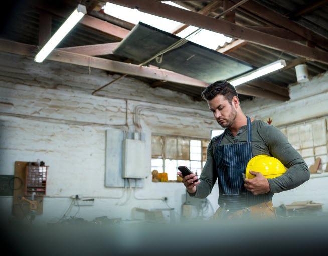 Man carrying yellow hard hat