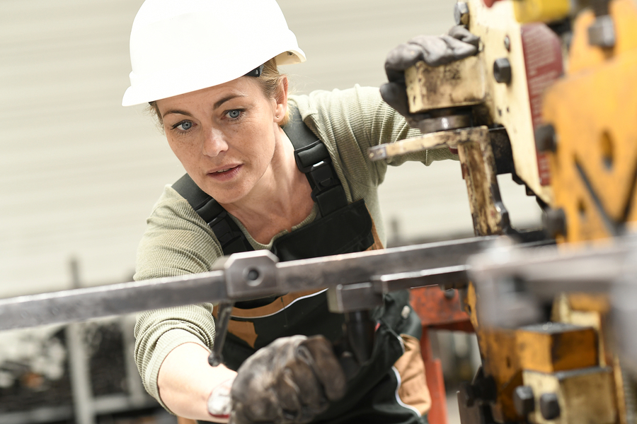 Woman in hardhat working in manufacturing