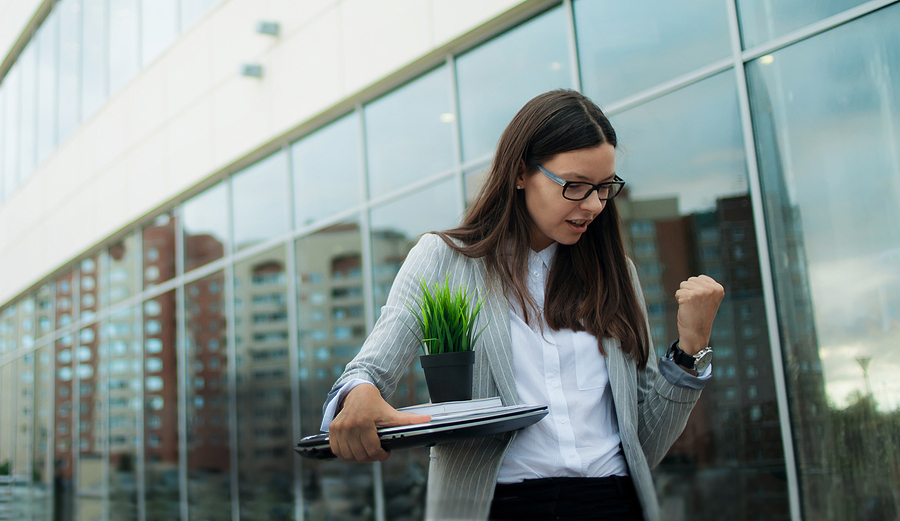 Woman leaving office with possessions after quitting job to take another