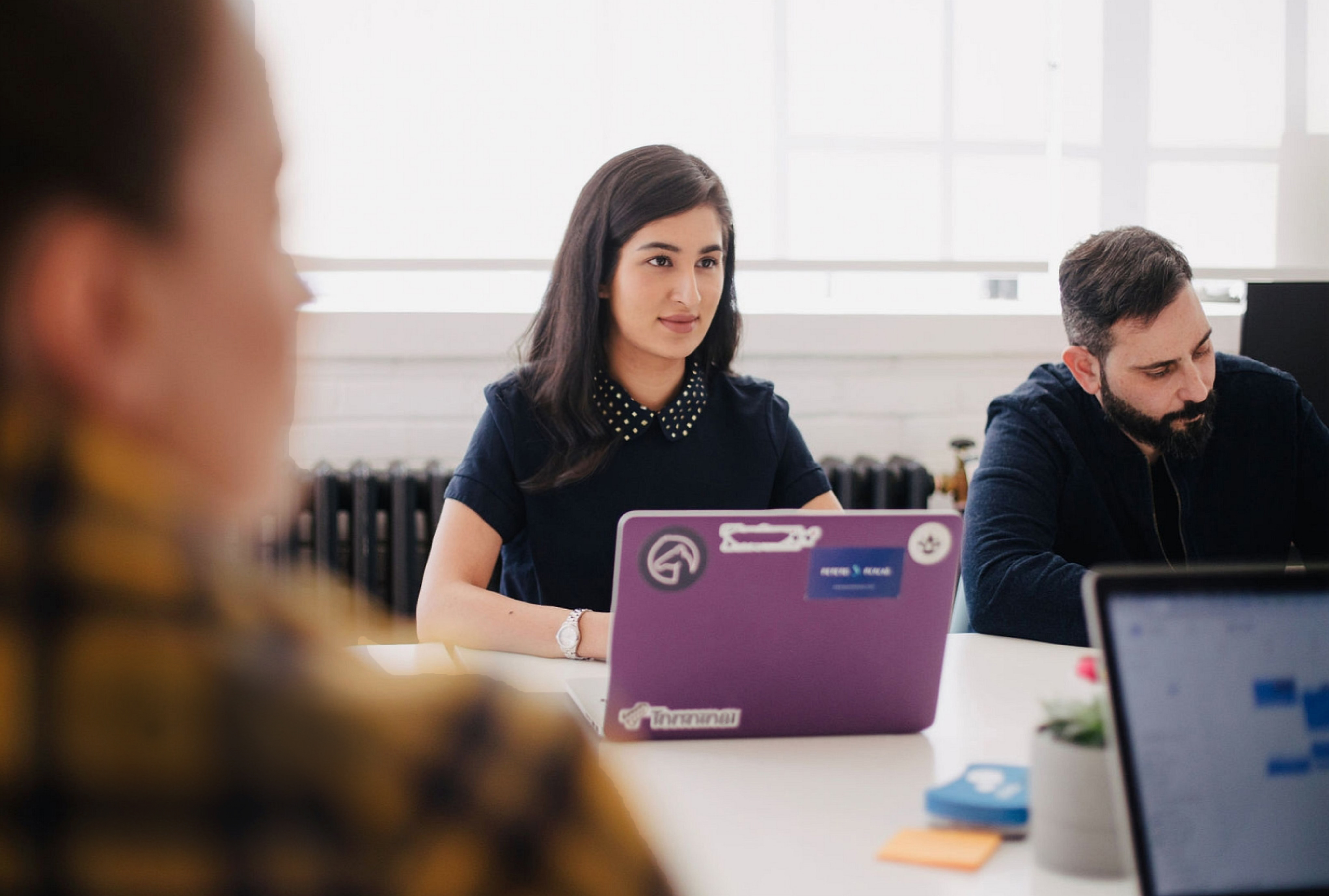 Young woman at laptop at meeting