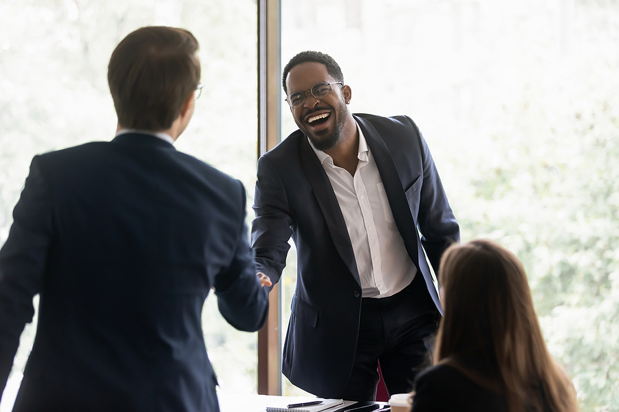 Newly hired worker shakes hands with hiring committee