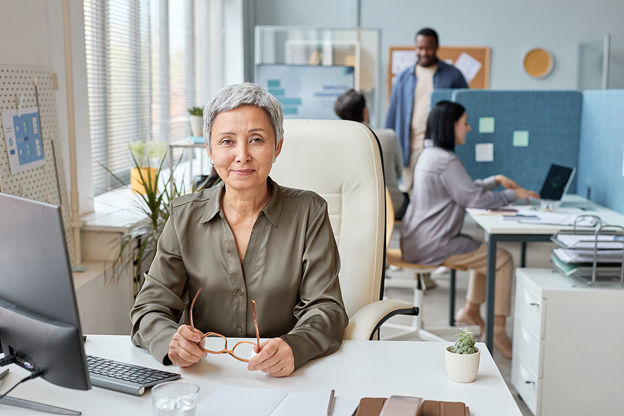 Older office worker sits at desk