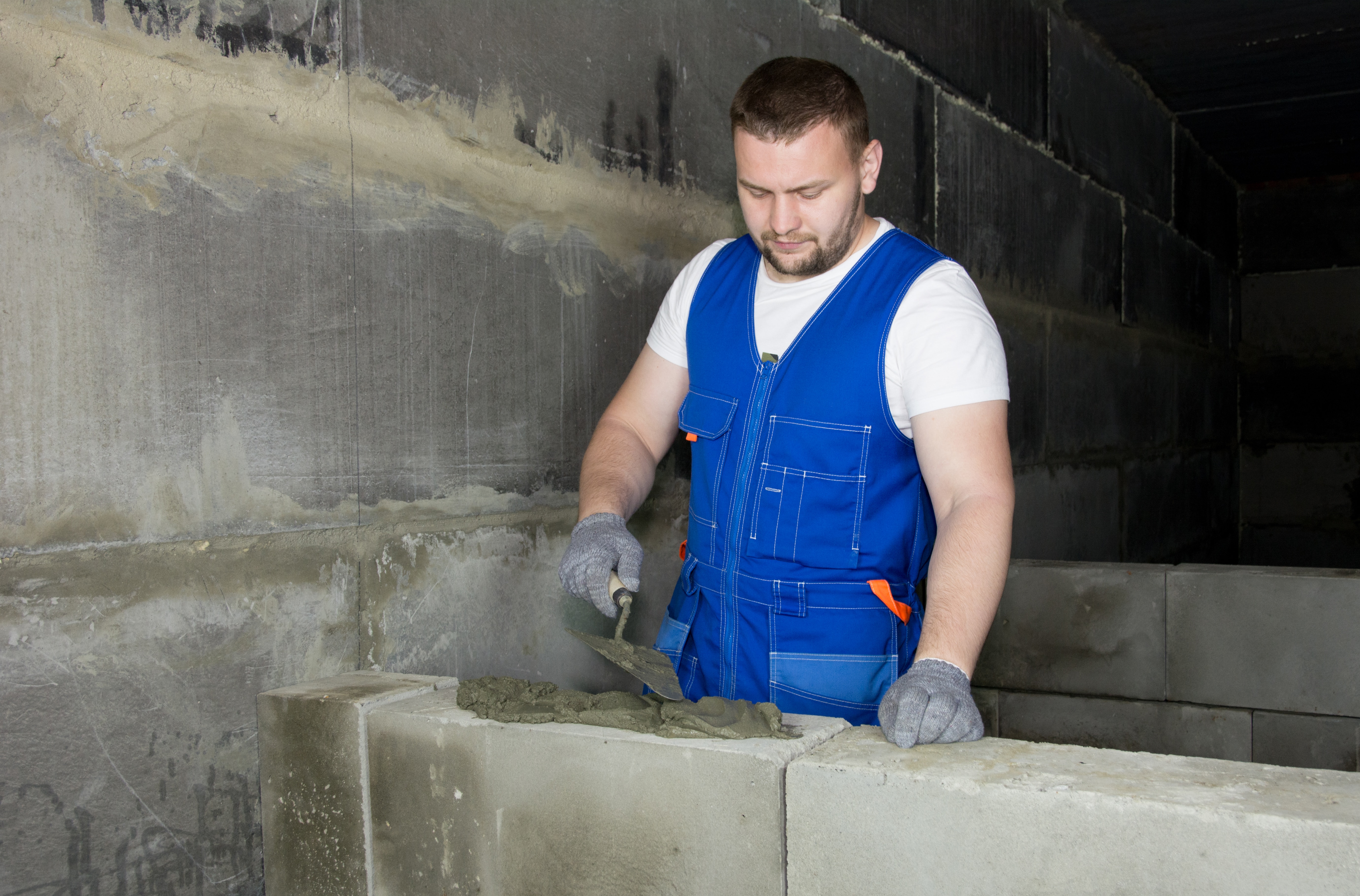 Construction-worker-white-man-grout-concrete-blocks