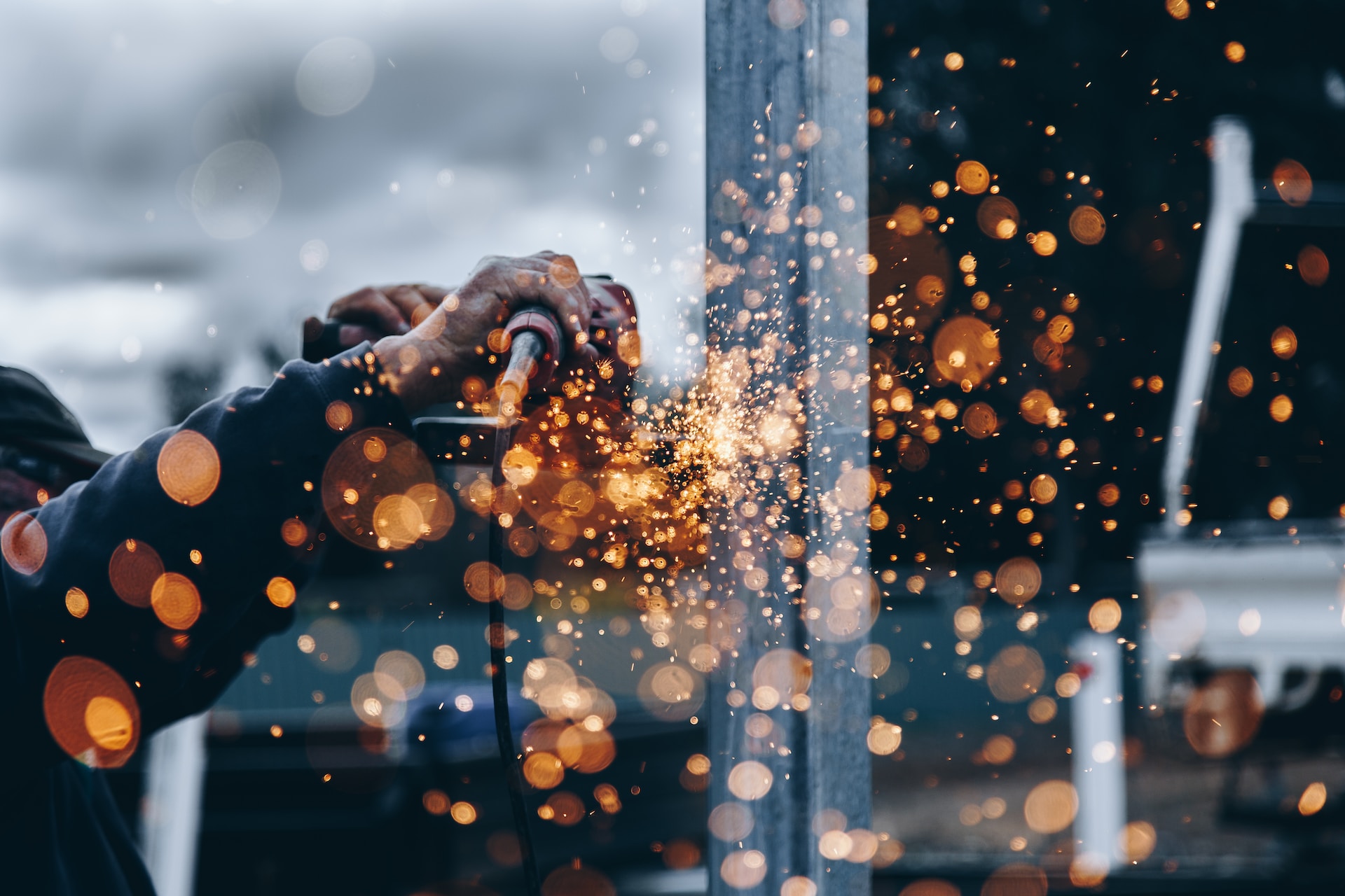 Sparks from factory work glow orange in abstract image