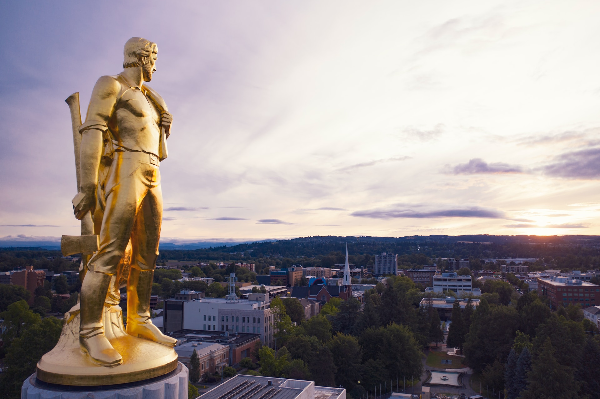 The golden pioneer atop the Capitol building looks at a sunset over Salem, Oregon.