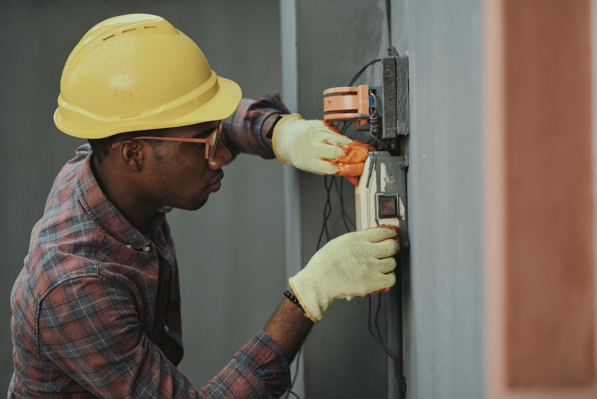 Man in hard hat examines elecrical box