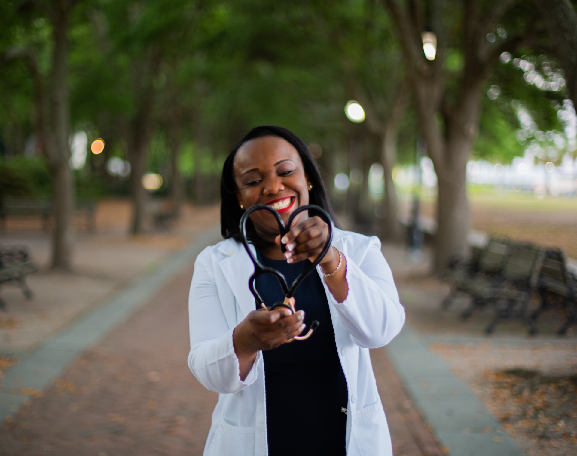 Doctor in park forms stethoscope into heart