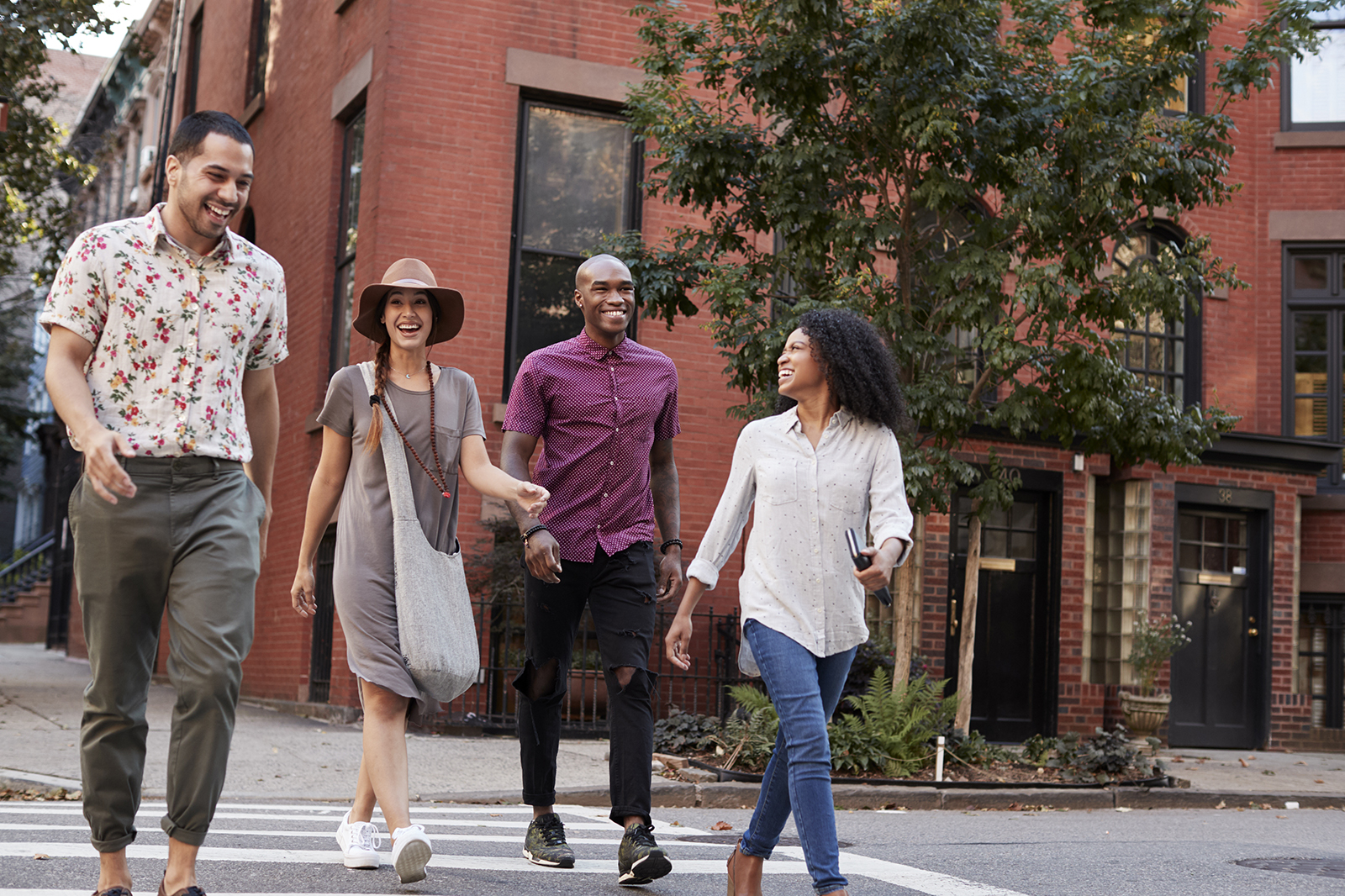 Four friends enjoy walking across a city street