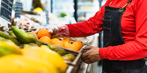 Women arranging supermarket fruits