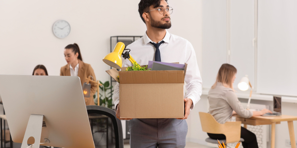 Young Man Leaving Job Carrying Box in Officeby africaimages