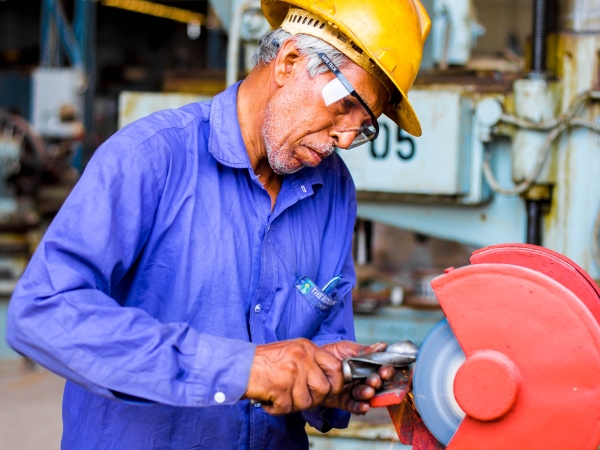 Worker grinds a drill bit