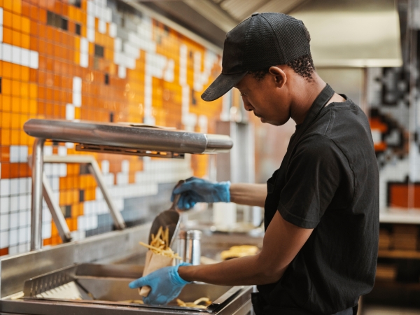 fast food worker preparing french fries