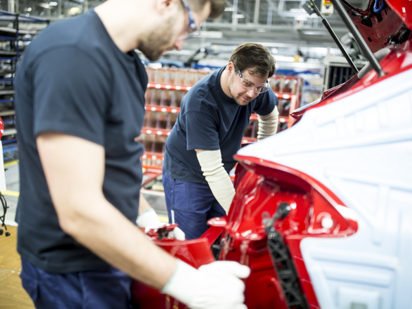 Two colleagues working in modern car factory by westend61