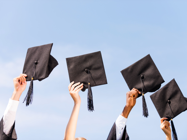 Graduates holding up their caps