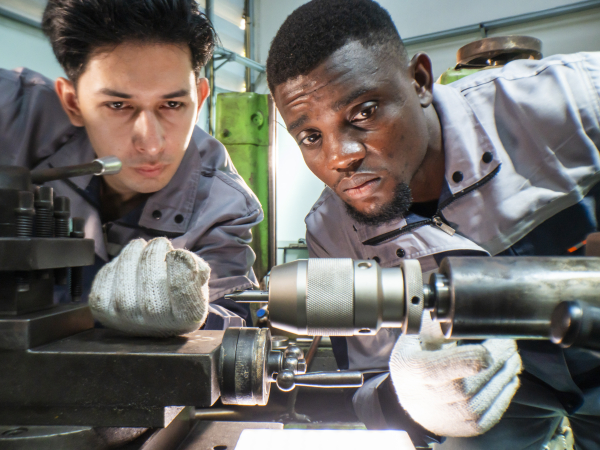 Two Machinists Working on Lathe in Factory Settingby ultramansk