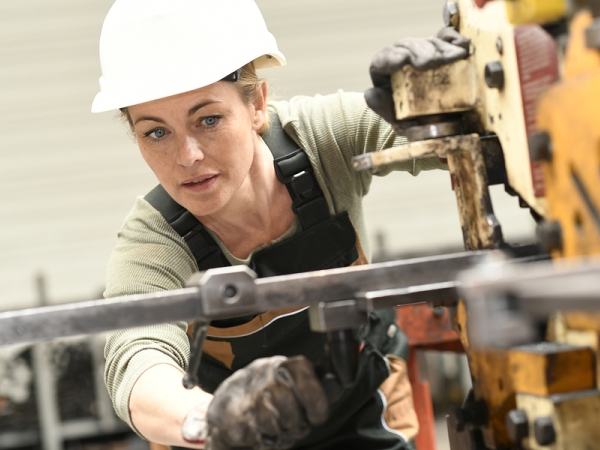 Woman in hardhat working in manufacturing