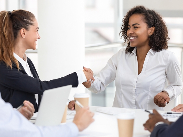 Woman shakes hand after being hired for new job