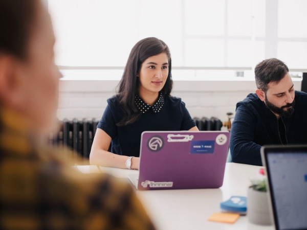 Young woman at laptop at meeting