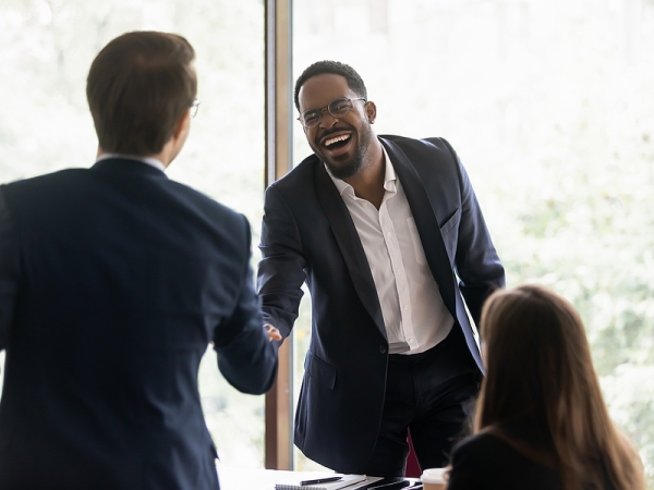 Newly hired worker shakes hands with hiring committee