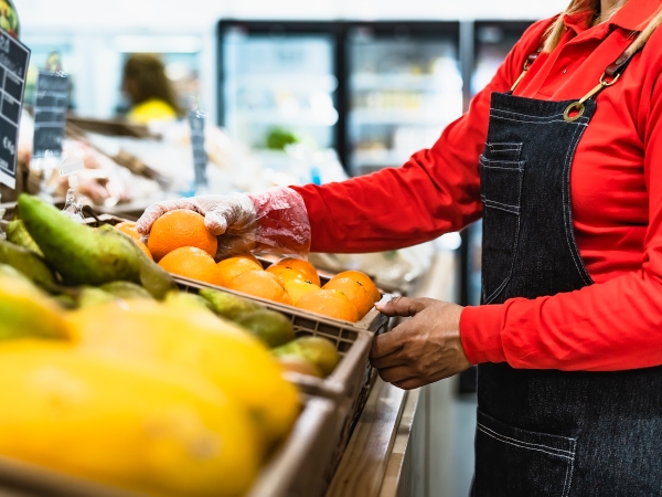 Women arranging supermarket fruits