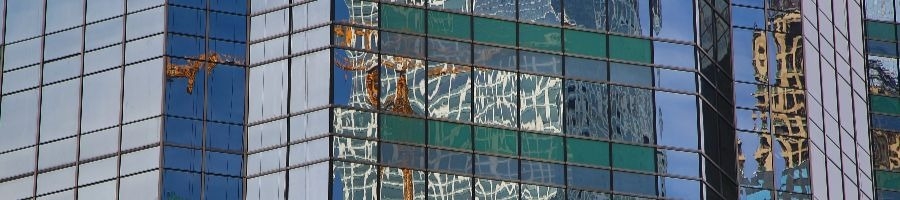 construction crane reflected in building windows