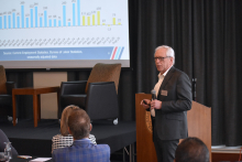 Upjohn Institute President Mike Horrigan standing in front of line graphs depicting economic information