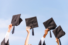 Graduates holding up their caps