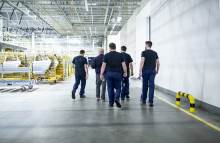 a group of workers walking together in a factory setting.