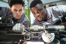 Two Machinists Working on Lathe in Factory Settingby ultramansk